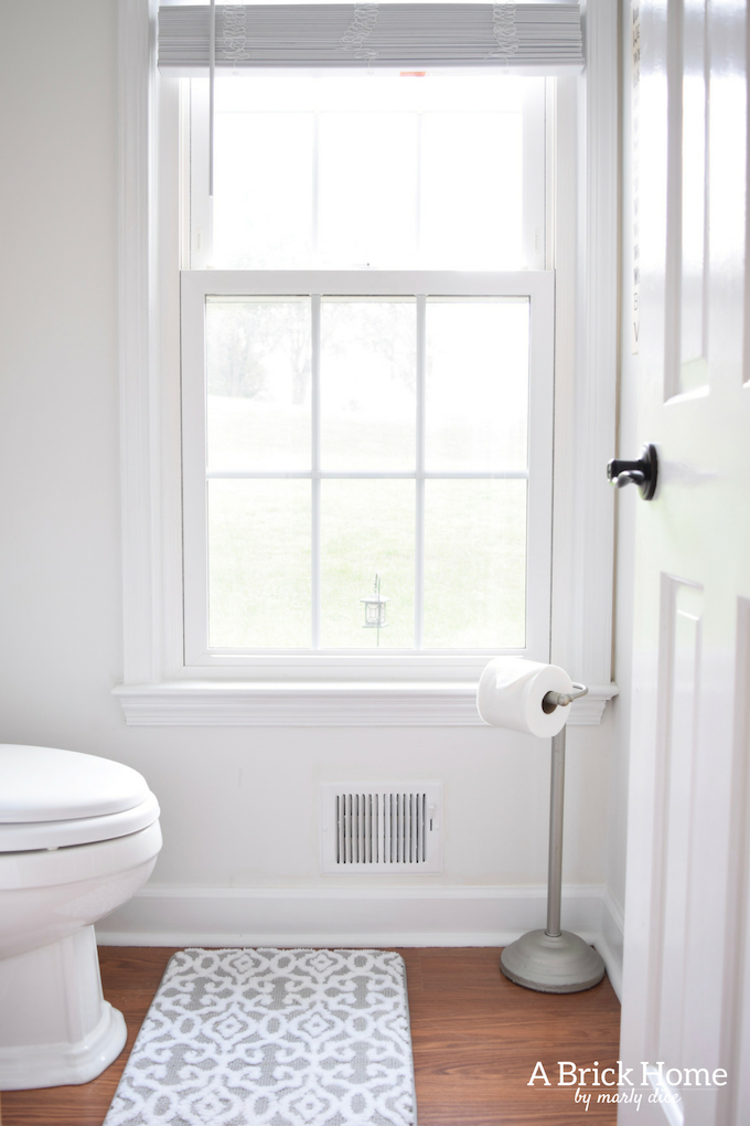 This powder room makeover REVEAL is insane! I can't believe how little money she spent to completely transform this powder room to a light and bright one. These small powder room ideas are must-see's!