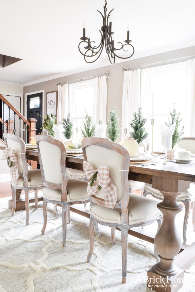 Gorgeous Dining Room Decked out in Transitional Fall to Winter Holiday Decor! A snowy tablescape with evergreens and pumpkins top off the almost Christmas decor look! #falldecor #winterdecor