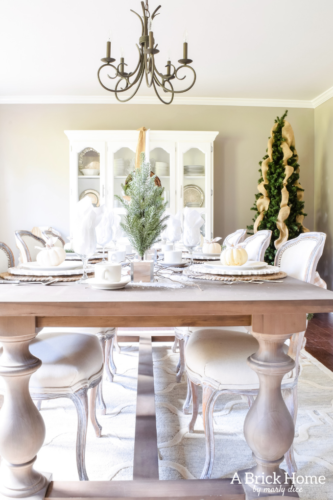 Gorgeous Dining Room Decked out in Transitional Fall to Winter Holiday Decor! A snowy tablescape with evergreens and pumpkins top off the almost Christmas decor look! #falldecor #winterdecor