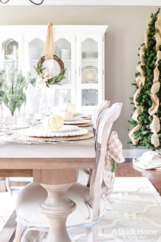 Gorgeous Dining Room Decked out in Transitional Fall to Winter Holiday Decor! A snowy tablescape with evergreens and pumpkins top off the almost Christmas decor look! #falldecor #winterdecor