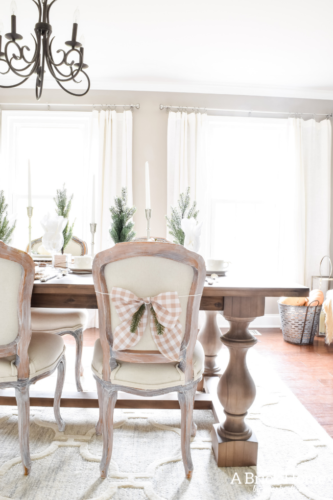 Gorgeous Dining Room Decked out in Transitional Fall to Winter Holiday Decor! A snowy tablescape with evergreens and pumpkins top off the almost Christmas decor look! #falldecor #winterdecor