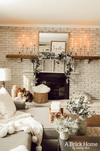 This cozy winter decor in her living room is so inviting! I love the way she styles the fireplace mantel decor. #cozywinterdecor