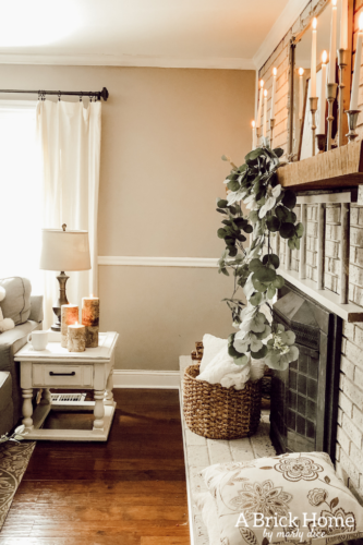 This cozy winter decor in her living room is so inviting! I love the way she styles the fireplace mantel decor. #cozywinterdecor