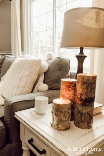 This cozy winter decor in her living room is so inviting! I love the way she styles the fireplace mantel decor. #cozywinterdecor