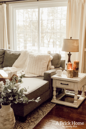 This cozy winter decor in her living room is so inviting! I love the way she styles the fireplace mantel decor. #cozywinterdecor