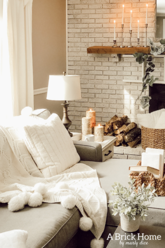This cozy winter decor in her living room is so inviting! I love the way she styles the fireplace mantel decor. #cozywinterdecor