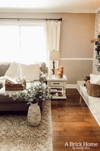 This cozy winter decor in her living room is so inviting! I love the way she styles the fireplace mantel decor. #cozywinterdecor