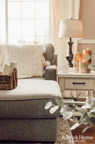 This cozy winter decor in her living room is so inviting! I love the way she styles the fireplace mantel decor. #cozywinterdecor