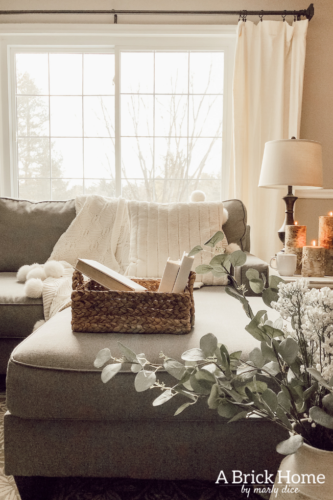 This cozy winter decor in her living room is so inviting! I love the way she styles the fireplace mantel decor. #cozywinterdecor