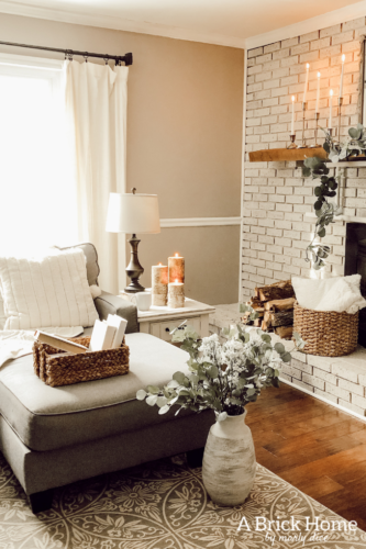 This cozy winter decor in her living room is so inviting! I love the way she styles the fireplace mantel decor. #cozywinterdecor