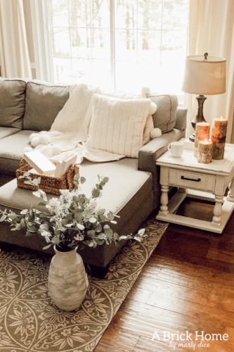 This cozy winter decor in her living room is so inviting! I love the way she styles the fireplace mantel decor. #cozywinterdecor