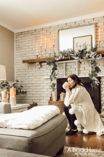 This cozy winter decor in her living room is so inviting! I love the way she styles the fireplace mantel decor. #cozywinterdecor