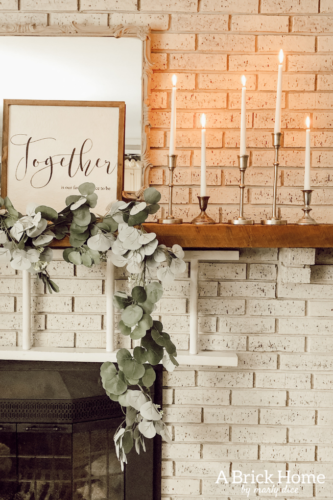 This cozy winter decor in her living room is so inviting! I love the way she styles the fireplace mantel decor. #cozywinterdecor