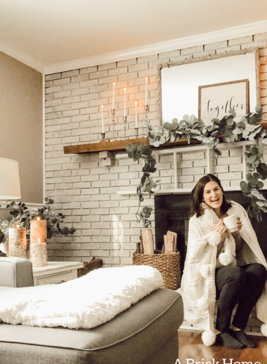 This cozy winter decor in her living room is so inviting! I love the way she styles the fireplace mantel decor. #cozywinterdecor