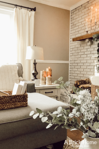 This cozy winter decor in her living room is so inviting! I love the way she styles the fireplace mantel decor. #cozywinterdecor