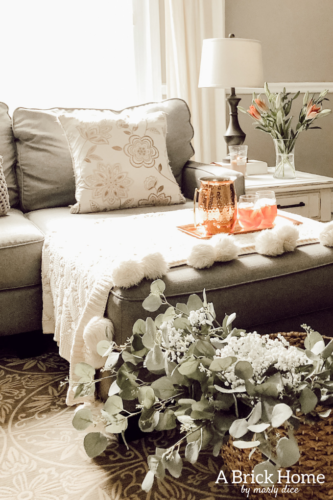 LOVE this spring living room decor with fresh flowers and a cozy blanket #livingroomdecor