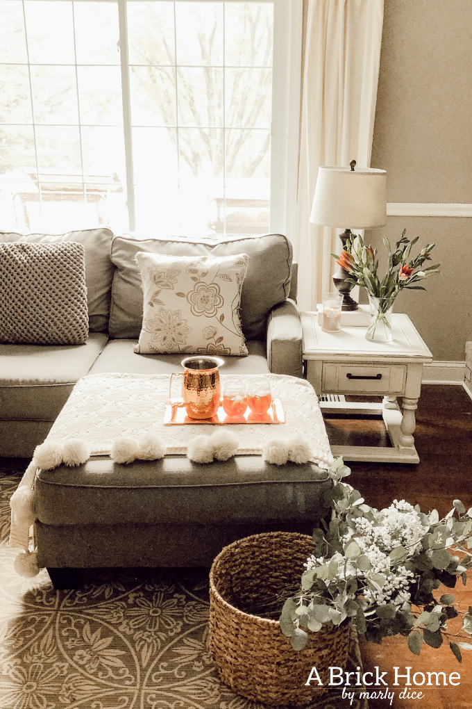 LOVE this spring living room decor with fresh flowers and a cozy blanket #livingroomdecor