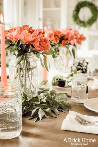 Dreamy spring tablescape using mason jars, candles and flowers! #springtablescape #masonjarideas