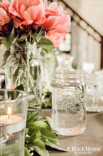 Dreamy spring tablescape using mason jars, candles and flowers! #springtablescape #masonjarideas
