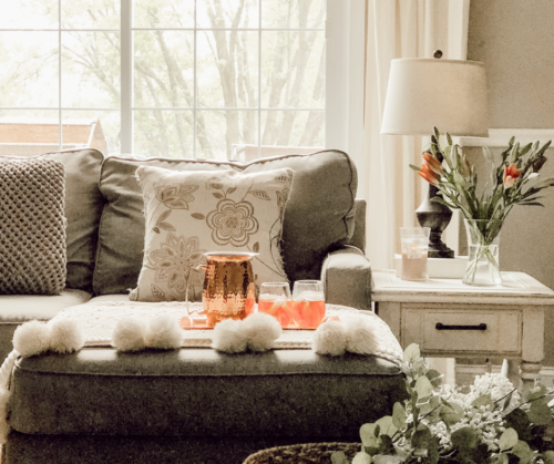 LOVE this spring living room decor with fresh flowers and a cozy blanket #livingroomdecor
