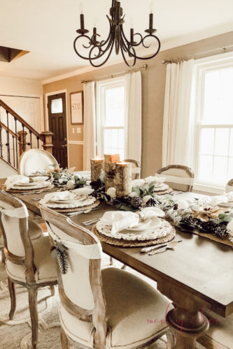 Loving this rustic winter tablescape and winter dining room decor! Beautiful use of eucalyptus and burlap together. #rusticwintertablescape #winterdecor #winterdiningroomdecor