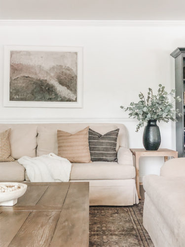 Neutral living room with Studio McGee side table and target finds on the bookcase.