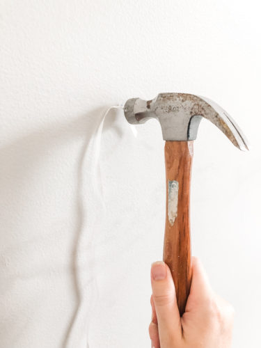Learn how to paint an arch on a wall in any room for a budget-friendly statement! See how she made a DIY compass to make this large arch look symmetrical. #archonawall