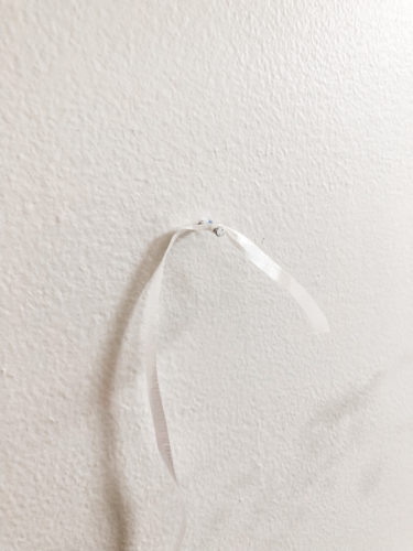 Learn how to paint an arch on a wall in any room for a budget-friendly statement! See how she made a DIY compass to make this large arch look symmetrical. #archonawall