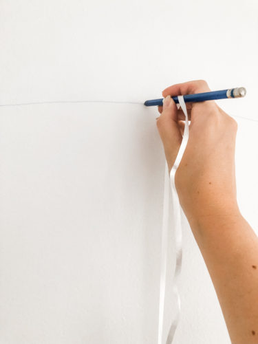 Learn how to paint an arch on a wall in any room for a budget-friendly statement! See how she made a DIY compass to make this large arch look symmetrical. #archonawall