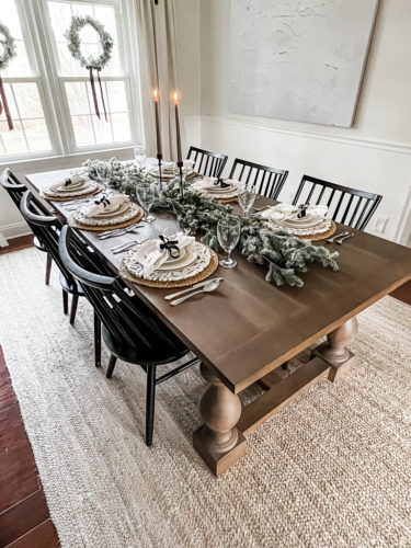 Neutral and rustic Christmas table decor using greenery, antlers and jute chargers #rusticchristmastabledecor #rusticchristmastablescape #rusticchristmasdecor