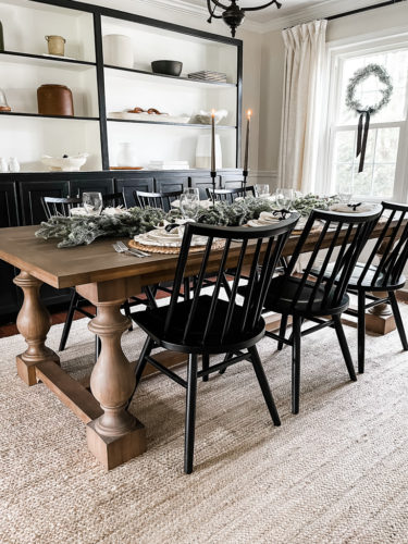 Neutral and rustic Christmas table decor using greenery, antlers and jute chargers #rusticchristmastabledecor #rusticchristmastablescape #rusticchristmasdecor