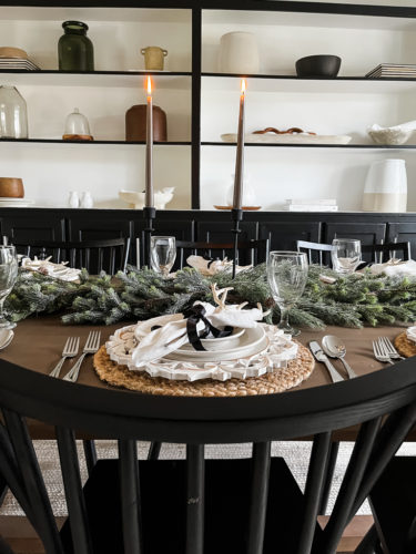 Neutral and rustic Christmas table decor using greenery, antlers and jute chargers #rusticchristmastabledecor #rusticchristmastablescape #rusticchristmasdecor