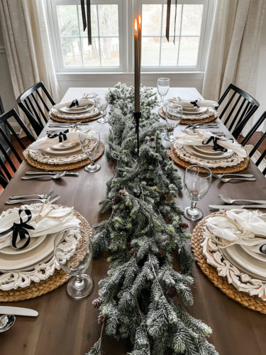 Neutral and rustic Christmas table decor using greenery, antlers and jute chargers #rusticchristmastabledecor #rusticchristmastablescape #rusticchristmasdecor