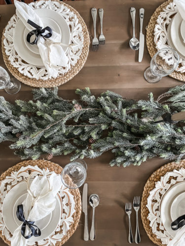 Neutral and rustic Christmas table decor using greenery, antlers and jute chargers #rusticchristmastabledecor #rusticchristmastablescape #rusticchristmasdecor