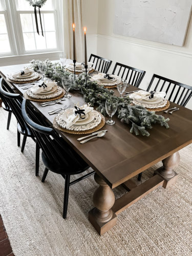 Neutral and rustic Christmas table decor using greenery, antlers and jute chargers #rusticchristmastabledecor #rusticchristmastablescape #rusticchristmasdecor