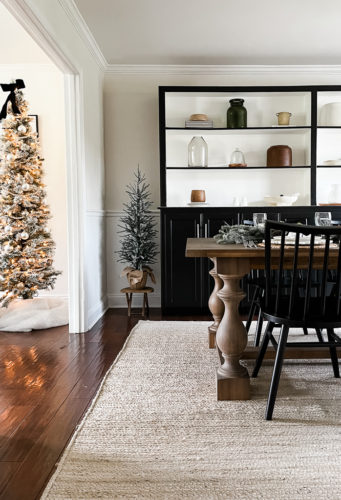 Neutral and rustic Christmas table decor using greenery, antlers and jute chargers #rusticchristmastabledecor #rusticchristmastablescape #rusticchristmasdecor