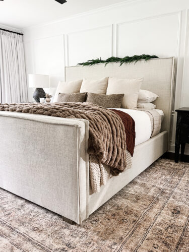 Moody and traditional Christmas bedroom using brown, red and green. Cozy Christmas bedroom decor #christmasbedroom #cozychristmasbedroomdecor